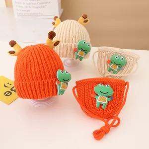 Detail of knitted winter hat and bag set with 3D deer antlers and green frog patch