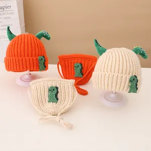 Close-up of knit texture on dinosaur baby beanie and matching mini crossbody bag set