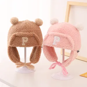 Winter plush trapper hats for kids featuring P patch and double faux fur pom poms