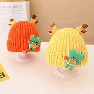 Detail view of orange and yellow knit hats with cute reindeer antlers and frog patches