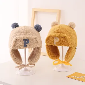 Kids warm winter trapper hat with double pom poms and P embroidery in beige and yellow