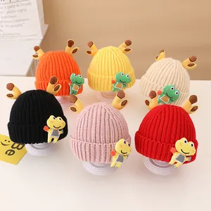 Detail showing colorful knitted kids' hats with cute antlers and cartoon frog charms
