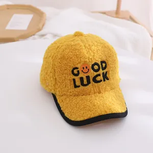Detail of yellow plush baseball cap for kids with GOOD LUCK letter embroidery and smiley