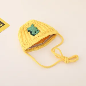 Close-up of kids yellow knit crossbody bag featuring a green dinosaur patch and zipper