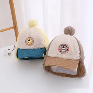 Dettaglio di caldi cappelli per neonati in lana d'agnello e velluto con pompon