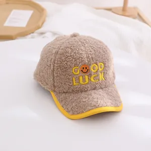 Detail of khaki fleece baseball cap with yellow GOOD LUCK embroidery and smiling face icon