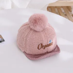 Détail de la casquette bébé en polaire rose avec broderie organic et pompon doux