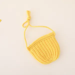Detail showing bright yellow hand-knitted mini shoulder bag for kids with strap