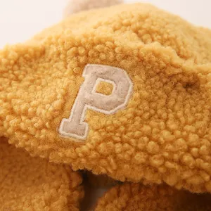 Detailed close-up of yellow fleece fabric with premium letter P embroidery on winter hat