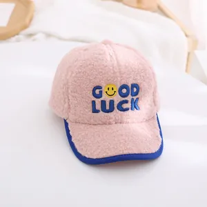 Close-up of pink lamb wool kids baseball cap featuring blue Good Luck embroidery