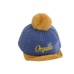 Casquette baseball enfant en polaire bleue avec pompon jaune et broderie Organic
