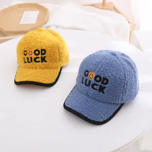 Detail of soft sherpa baseball hats for kids with Good Luck embroidery in yellow and blue