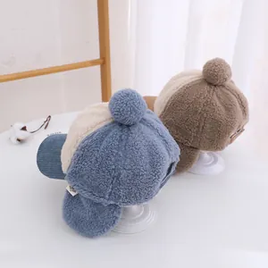 Dettaglio di berretti invernali per bambini con paraorecchie in velluto e peluche