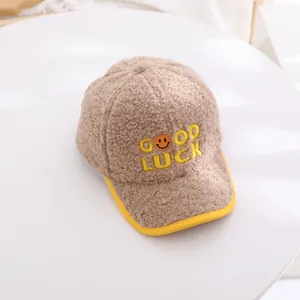 Close-up of fluffy brown fleece kids baseball cap with yellow Good Luck embroidery