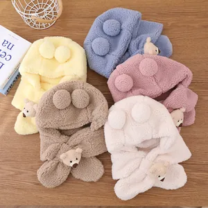 Vue à plat de sweats à capuche en peluche pour enfants avec pompons sur bois
