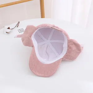Dettaglio del cappello invernale rosa per neonati con velluto a coste e fodera