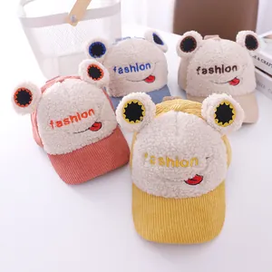 Detail of cute kids frog baseball caps in corduroy and sherpa with fashion embroidery