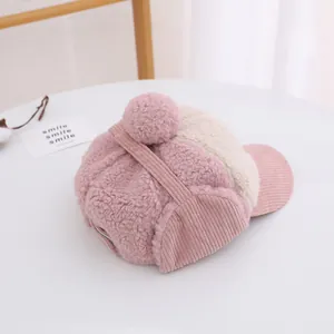 Dettaglio cappello invernale bimbi in velluto rosa con pompon e paraorecchie morbidi