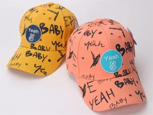 Close-up of yellow and pink cotton baseball caps with graffiti baby letters and hand logo