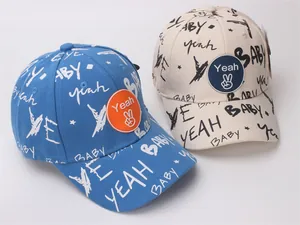 Detail of canvas baby baseball caps featuring graffiti prints and silicone hand sign patches