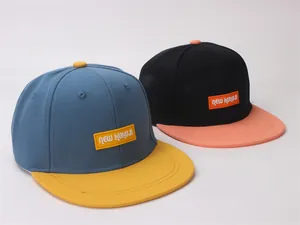 Detail of color-block kids snapback hats featuring NEW KUKUJI embroidered square patches