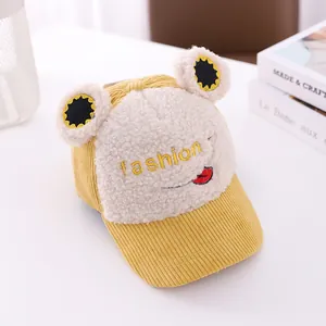 Detail of yellow kids cartoon baseball cap featuring corduroy and warm lamb wool fabric