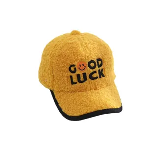 Warm yellow fleece baseball cap with Good Luck embroidery and orange smiley face for kids