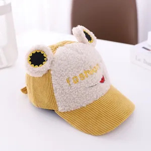 Detail of yellow corduroy frog child hat with plush ears and fashion embroidery