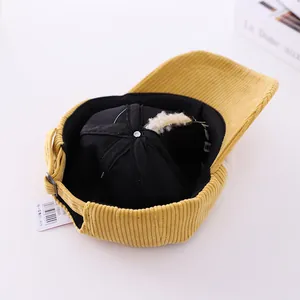 Detail view of yellow corduroy kids cap with adjustable metal strap and soft inner lining