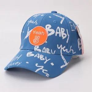 Detail of blue cotton baby baseball cap featuring graffiti letters and orange silicone patch