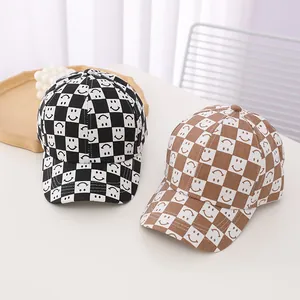 Close-up of checkerboard baseball caps with smiley face embroidery on a wooden tray