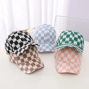 Macro detail of kids baseball caps featuring smiley faces and checkerboard patterns