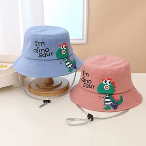 Detalle del estampado de dinosaurio y correa ajustable en sombrero de sol infantil