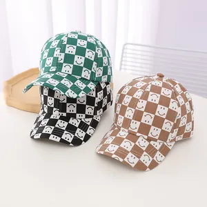 Detailed view of kids' checkerboard baseball caps with smiley face prints in three colors