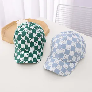 Detail view of blue and green checkered kids baseball caps with happy smiley prints