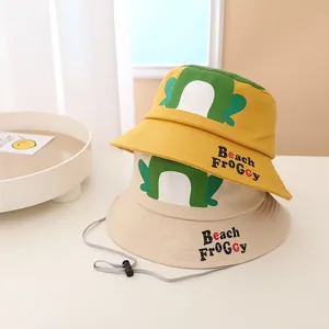 Detail view of cotton sun hats in yellow and beige with frog print and windproof drawstrings