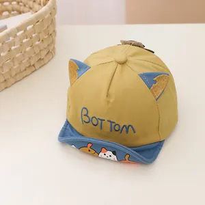 Detail of baby soft brim baseball cap featuring blue cartoon embroidery and cat ears