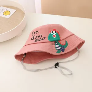 Detalle del sombrero de sol rosa con estampado de dinosaurio y correa ajustable para barbilla
