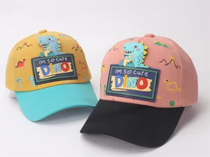 Detail of children's baseball caps featuring 3D cartoon dinosaur patches and cotton fabric