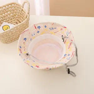 Détail d'un chapeau bob beige pour enfant avec motifs graffiti colorés et cordon ajustable