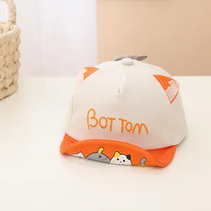 Detailed close-up of soft-brim baby baseball cap with cute cartoon cat and pig patterns