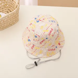 Détail d'un chapeau bob bébé beige avec motifs graffiti colorés et cordon de serrage