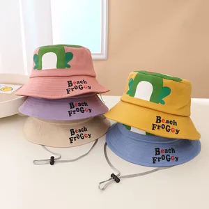 Detail showing colorful cotton frog sun hats with adjustable drawstrings and cartoon eyes