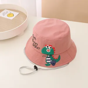 Detalle de gorro tipo pescador rosa para niños con estampado de dinosaurio y cordón ajustable
