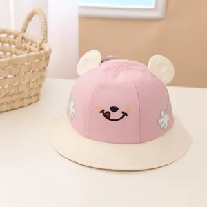 Detail of pink cotton baby sun hat with cute bear ears and smiley face embroidery