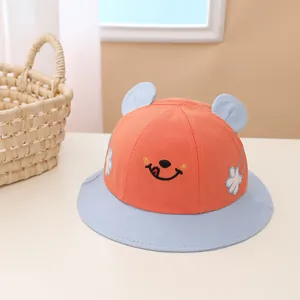Detail of kids sun hat featuring cute cartoon smile embroidery and decorative ears