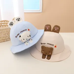 Detail of baby sun hats featuring plush bear ears and cute embroidery in light blue and beige