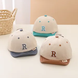 Three infant cotton baseball caps with soft brims in blue, green and brown colors