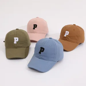 Detailed view of candy-colored kids baseball caps with embroidered P letter logo