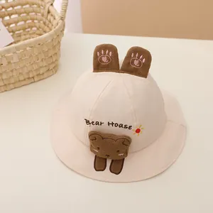 Close-up of baby sun hat with cute bear face embroidery and plush ears detail